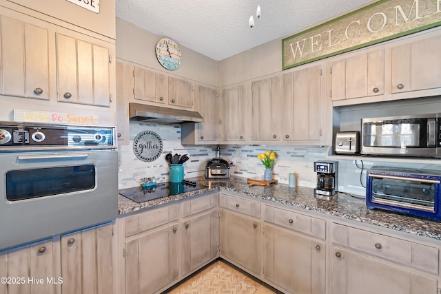 kitchen with black appliances, decorative backsplash, a textured ceiling, and dark stone counters