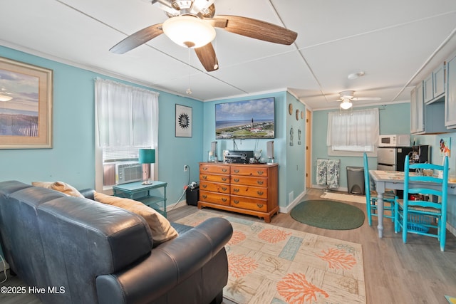 living room featuring light hardwood / wood-style floors, cooling unit, and ornamental molding