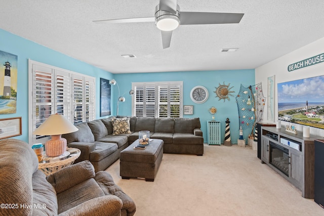 carpeted living room featuring radiator, a textured ceiling, and ceiling fan