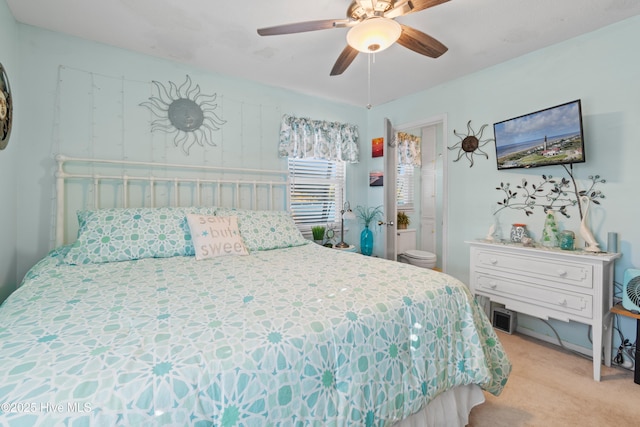 carpeted bedroom featuring ensuite bath and ceiling fan