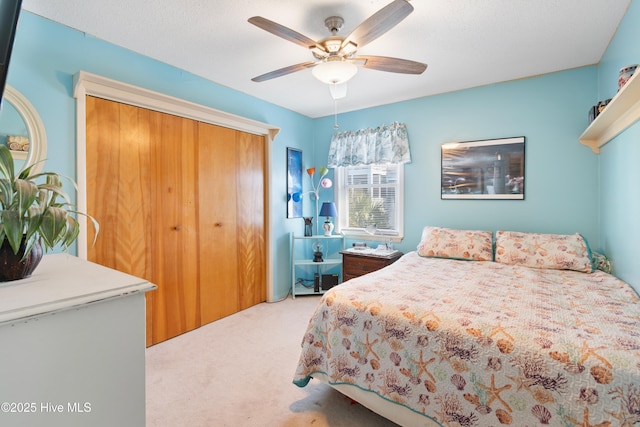 carpeted bedroom with ceiling fan and a closet