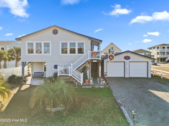 view of front of home with a porch, a front yard, and a garage