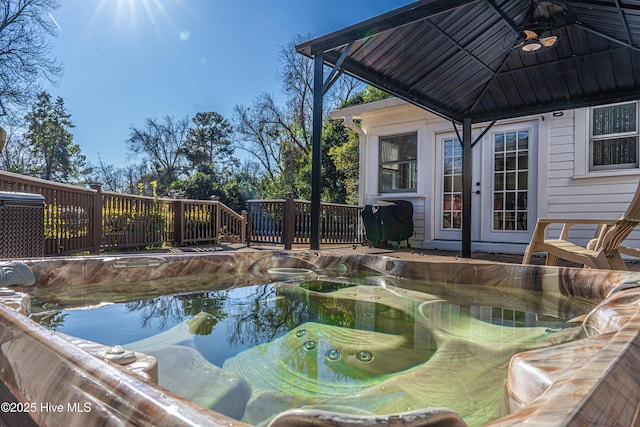 view of swimming pool with french doors, a hot tub, and a grill