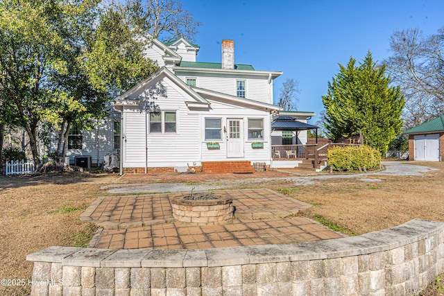 back of property with a fire pit, a gazebo, a patio, and a wooden deck