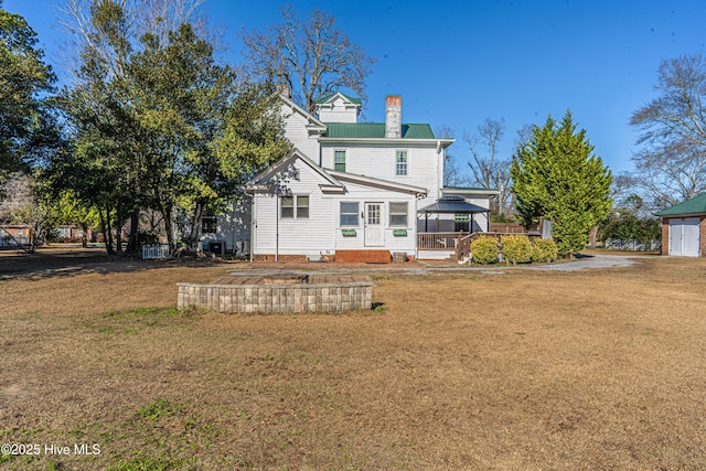 rear view of house featuring a lawn