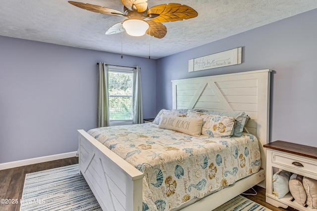 bedroom with ceiling fan, a textured ceiling, and dark wood-type flooring