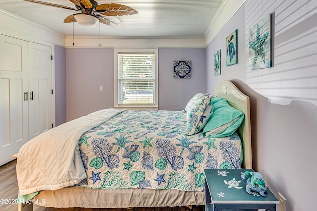 bedroom featuring hardwood / wood-style floors, a closet, ceiling fan, and ornamental molding