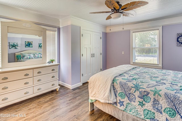 bedroom with wood-type flooring, a closet, ceiling fan, and ornamental molding