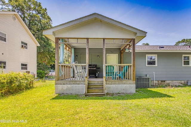 back of house featuring a lawn, covered porch, and central AC unit