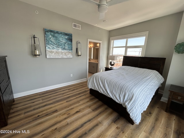 bedroom featuring ceiling fan, ensuite bath, and dark wood-type flooring