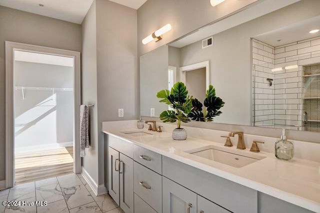 bathroom featuring a shower with door and vanity