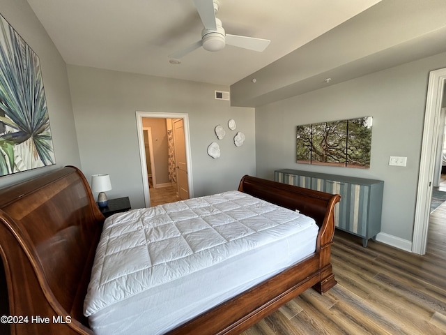 bedroom with wood-type flooring, connected bathroom, and ceiling fan