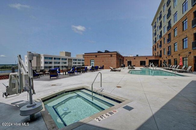 view of pool featuring a hot tub and a patio