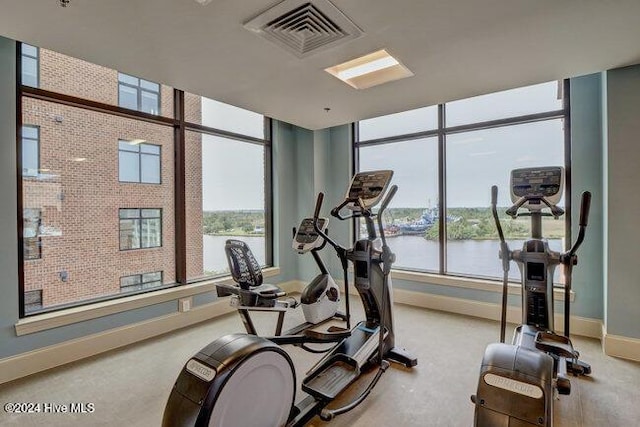 exercise room with a water view