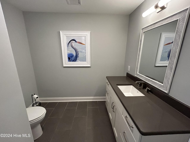 bathroom with vanity, tile patterned flooring, and toilet