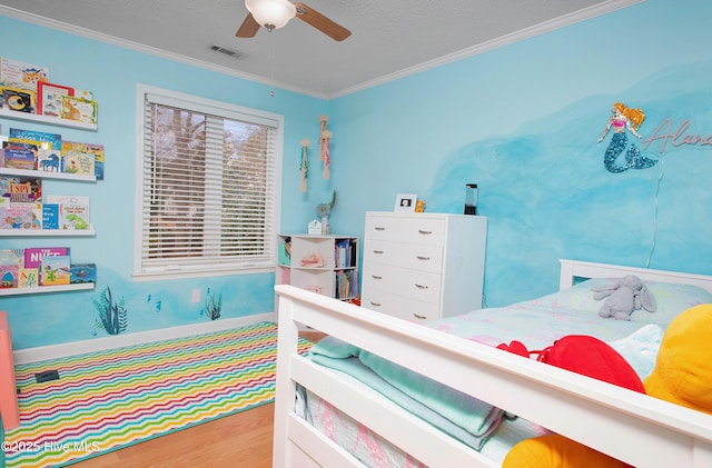 bedroom featuring ceiling fan, ornamental molding, a textured ceiling, and hardwood / wood-style flooring