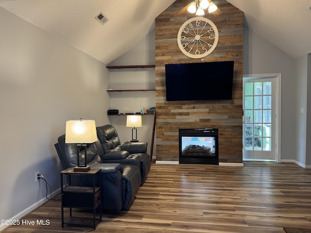 living area with high vaulted ceiling, wood finished floors, a multi sided fireplace, visible vents, and baseboards