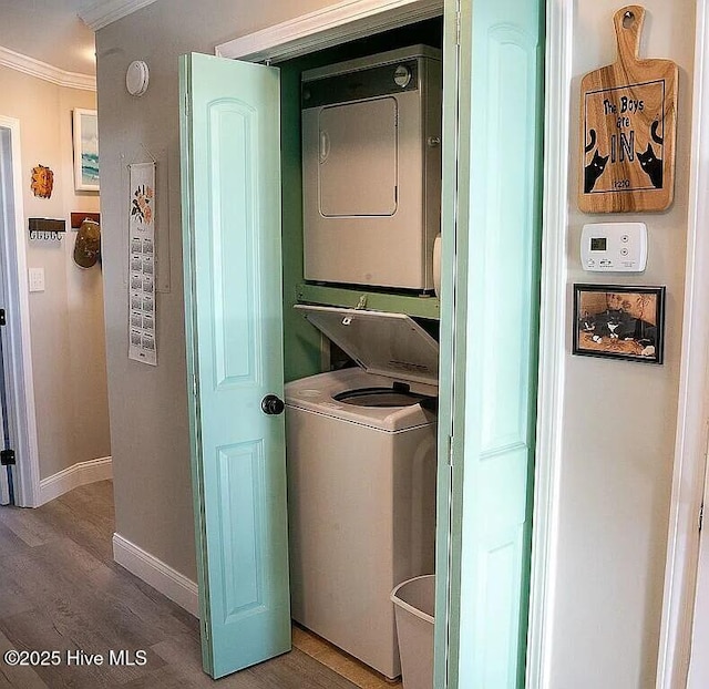 clothes washing area with wood-type flooring, stacked washer / dryer, and crown molding