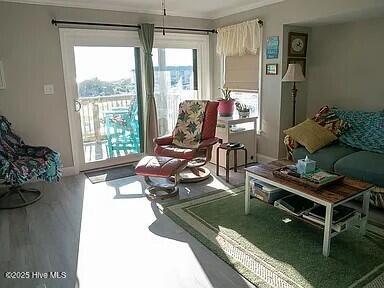 living room featuring hardwood / wood-style floors and crown molding