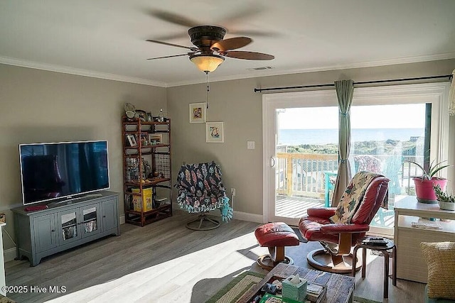 sitting room with ceiling fan, wood-type flooring, and crown molding