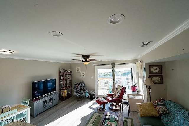 living room with hardwood / wood-style floors, ceiling fan, and crown molding