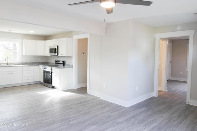 kitchen with stainless steel appliances, ceiling fan, sink, light hardwood / wood-style flooring, and white cabinets