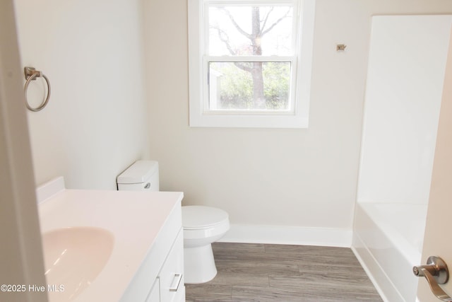 bathroom with hardwood / wood-style floors, vanity, and toilet