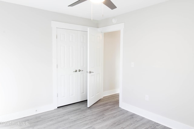 unfurnished bedroom featuring ceiling fan, light hardwood / wood-style floors, and a closet