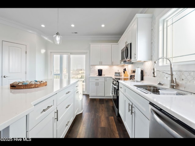 2083 New River Inlet Rd Unit A, North Topsail Beach, NC 28460 - kitchen featuring appliances with stainless steel finishes, a sink, white cabinetry, decorative backsplash, and ornamental molding