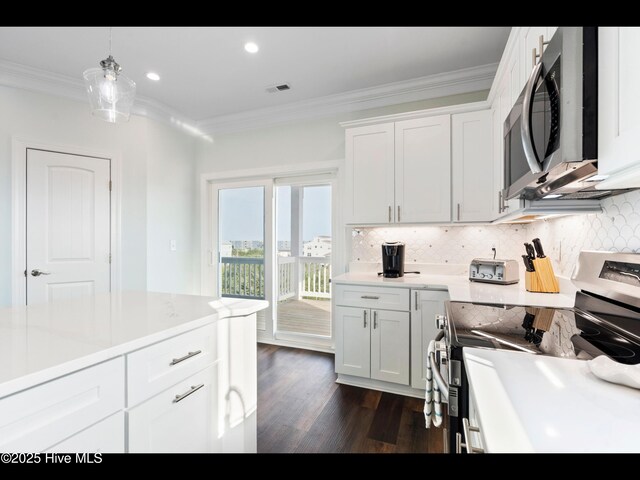 2083 New River Inlet Rd Unit A, North Topsail Beach, NC 28460 - kitchen featuring appliances with stainless steel finishes, crown molding, decorative backsplash, dark wood finished floors, and hanging light fixtures