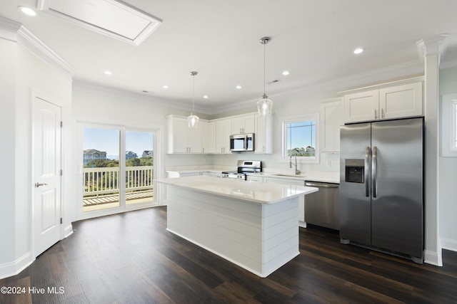 kitchen featuring appliances with stainless steel finishes, a center island, white cabinetry, and hanging light fixtures