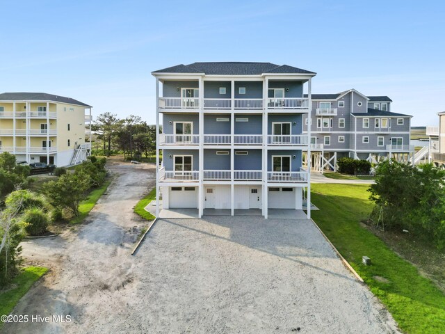 2083 New River Inlet Rd Unit A, North Topsail Beach, NC 28460 - rear view of property featuring driveway, an attached garage, a balcony, a yard, and a shingled roof