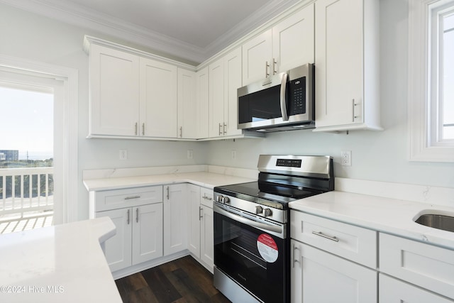 kitchen featuring white cabinetry, dark hardwood / wood-style flooring, ornamental molding, and appliances with stainless steel finishes