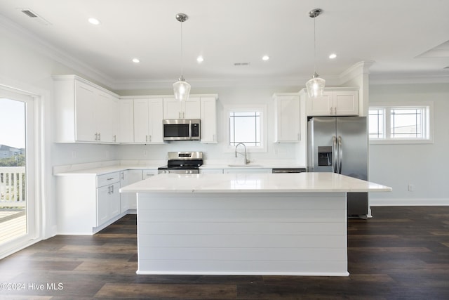 kitchen with sink, stainless steel appliances, white cabinets, pendant lighting, and a kitchen island