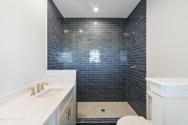 bathroom featuring tiled shower, vanity, and toilet