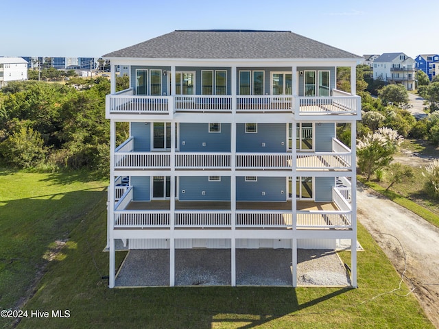 2083 New River Inlet Rd Unit A, North Topsail Beach, NC 28460 - rear view of property featuring a balcony, a shingled roof, and a yard