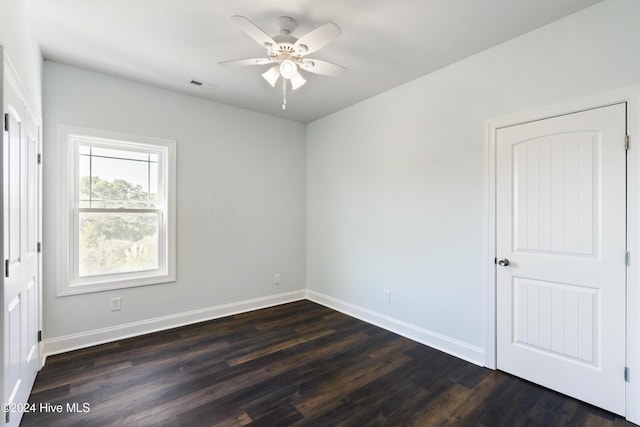 spare room featuring ceiling fan and dark wood-type flooring