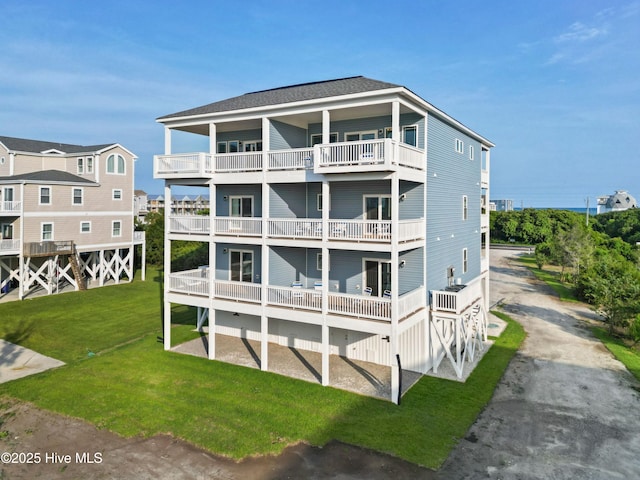 2083 New River Inlet Rd Unit A, North Topsail Beach, NC 28460 - rear view of house featuring a balcony, asphalt driveway, and a yard
