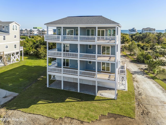 rear view of house with a balcony and a lawn