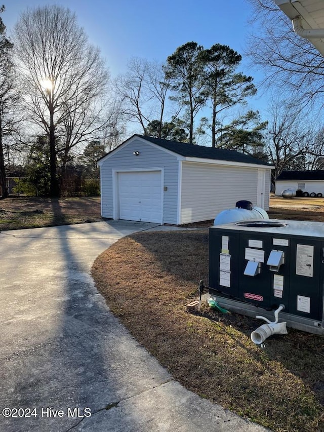 exterior space with cooling unit, an outdoor structure, and a garage