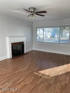 unfurnished living room featuring ceiling fan and dark wood-type flooring