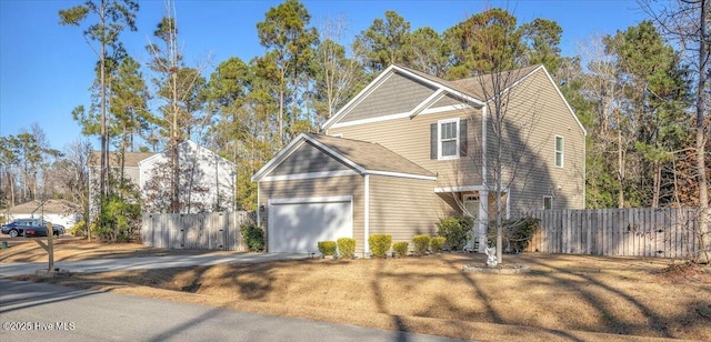 view of front facade featuring an attached garage, fence, and concrete driveway