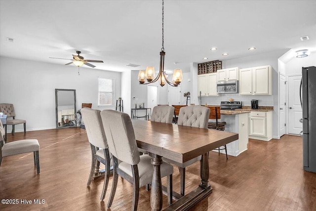 dining area featuring recessed lighting, ceiling fan with notable chandelier, visible vents, baseboards, and dark wood-style floors