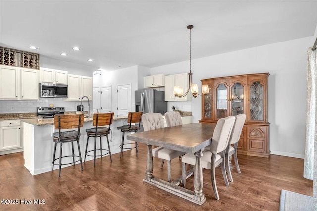 dining room featuring baseboards, dark wood-style flooring, recessed lighting, and a notable chandelier