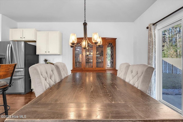 dining room featuring dark wood-style floors and a notable chandelier