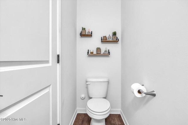 bathroom with toilet, baseboards, and wood finished floors