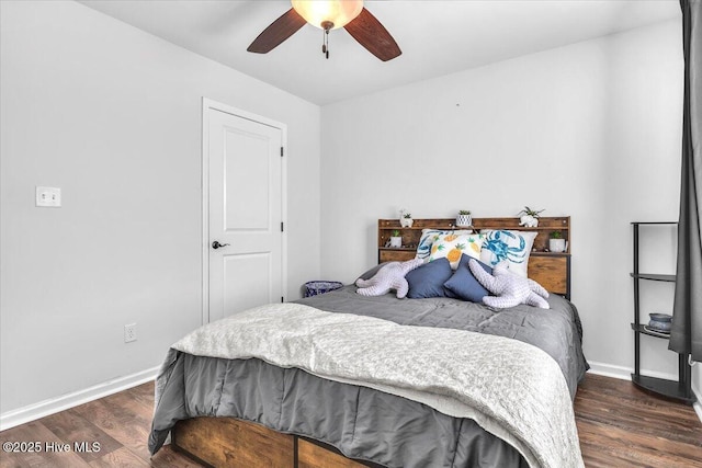 bedroom with dark wood-type flooring, a ceiling fan, and baseboards