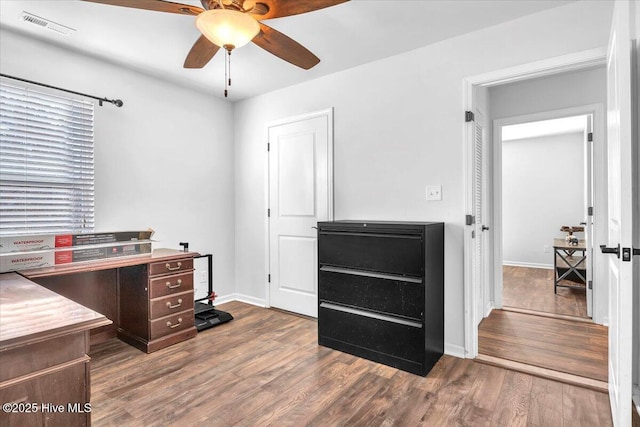 office with ceiling fan, wood finished floors, visible vents, and baseboards