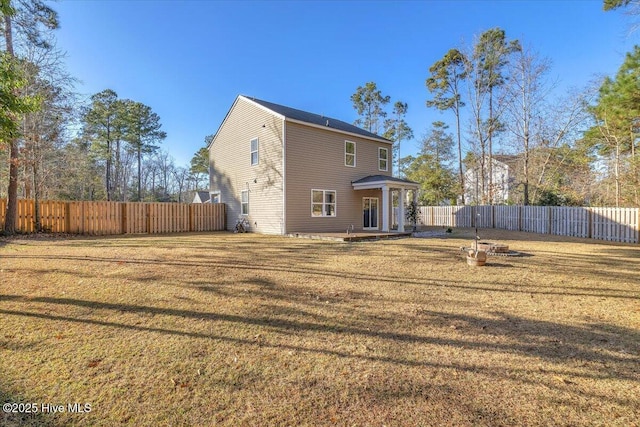 back of property featuring a fenced backyard and a lawn