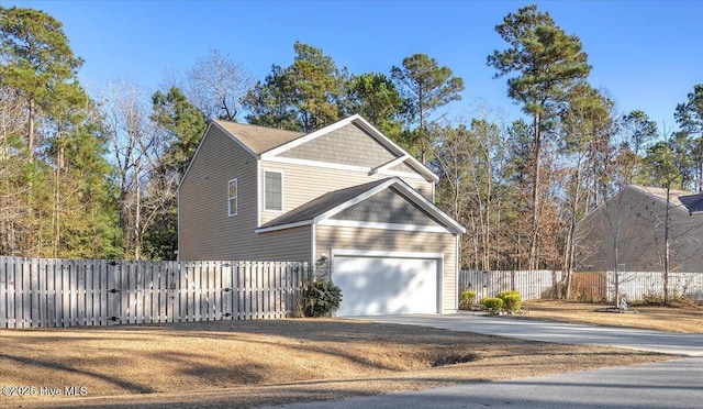 view of home's exterior featuring fence and driveway